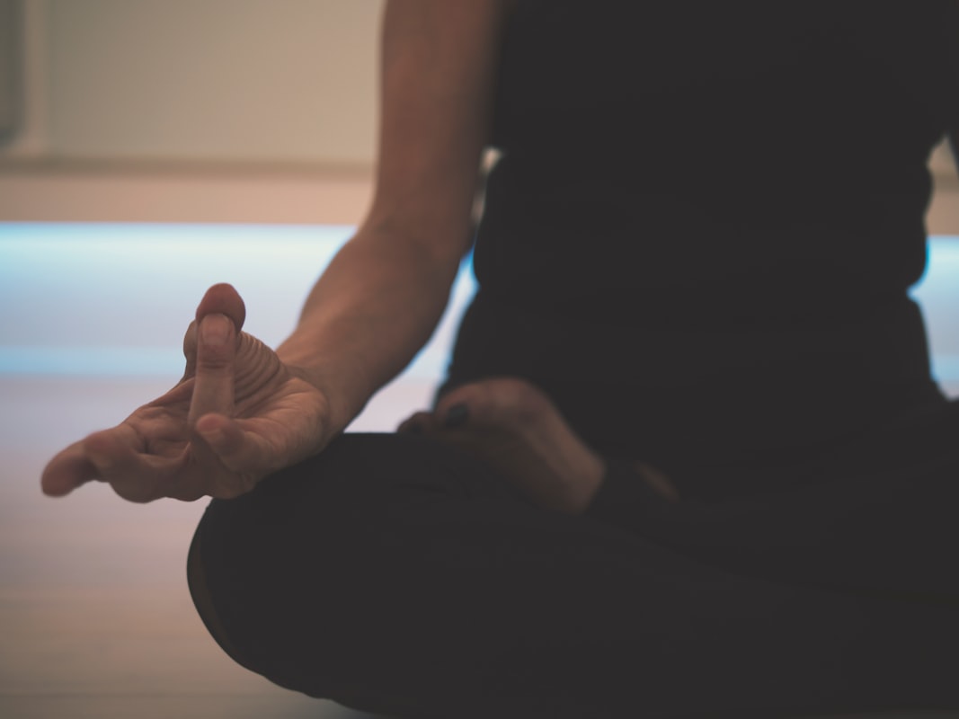 Person meditating in serene natural environment